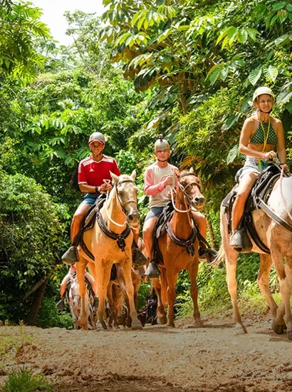 Tourists enjoying a horseback riding trail through the jungle at La Hacienda Park, Punta Cana.